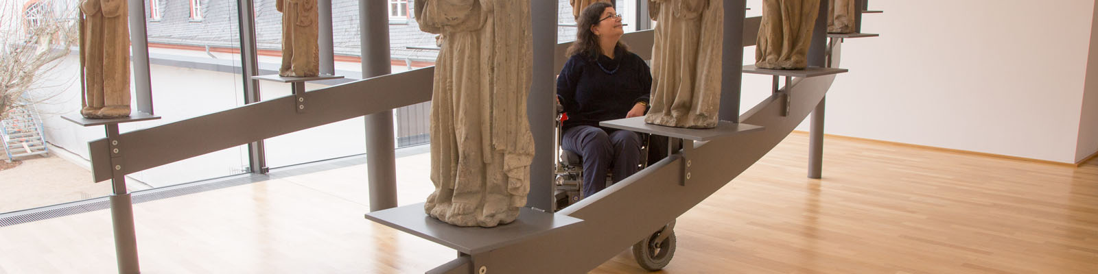 Frau im Rollstuhl besichtigt Ausstellungsstücke